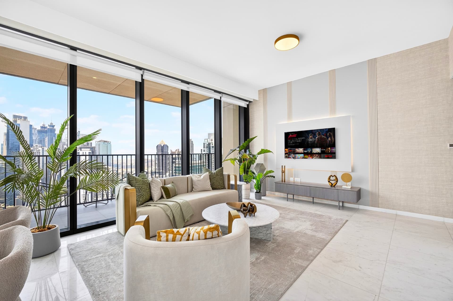 Boulevard Heights lounge with curved armchair, marble table, and media wall